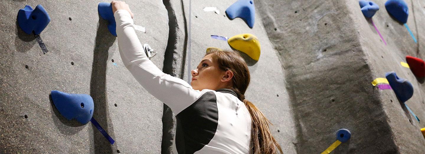 Student climbing rock wall